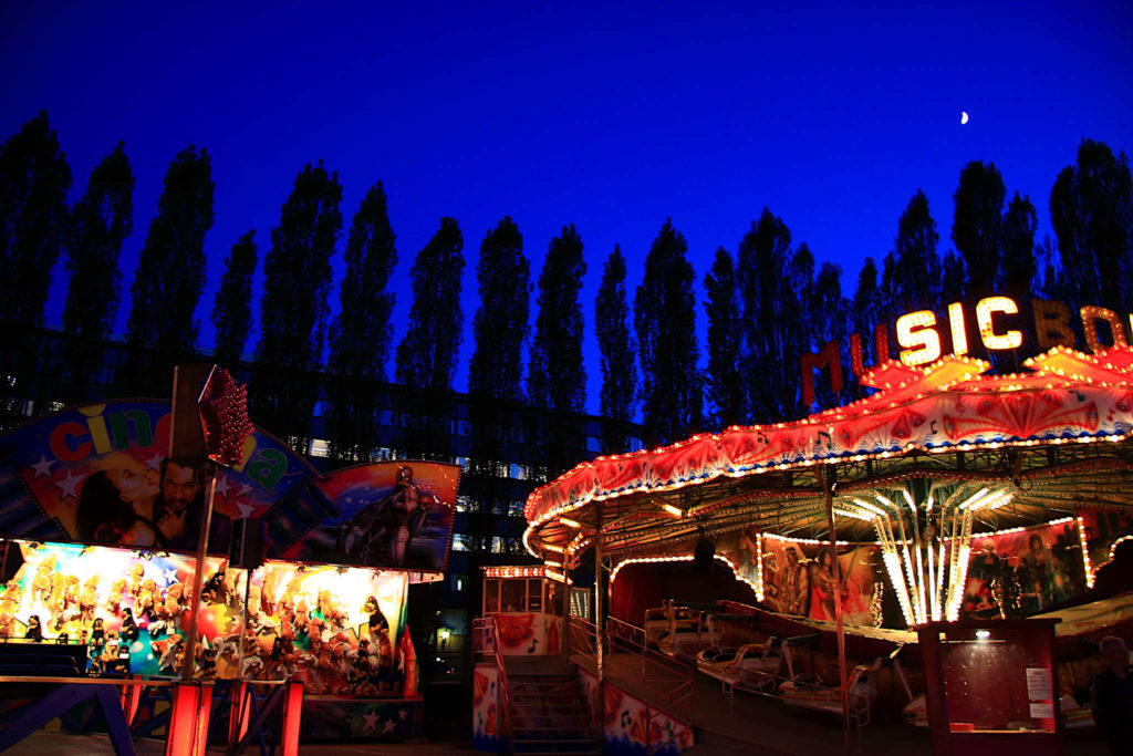 A picture of a carnival i Oslo at night. Dark sky and the carnival is full of colors and light.